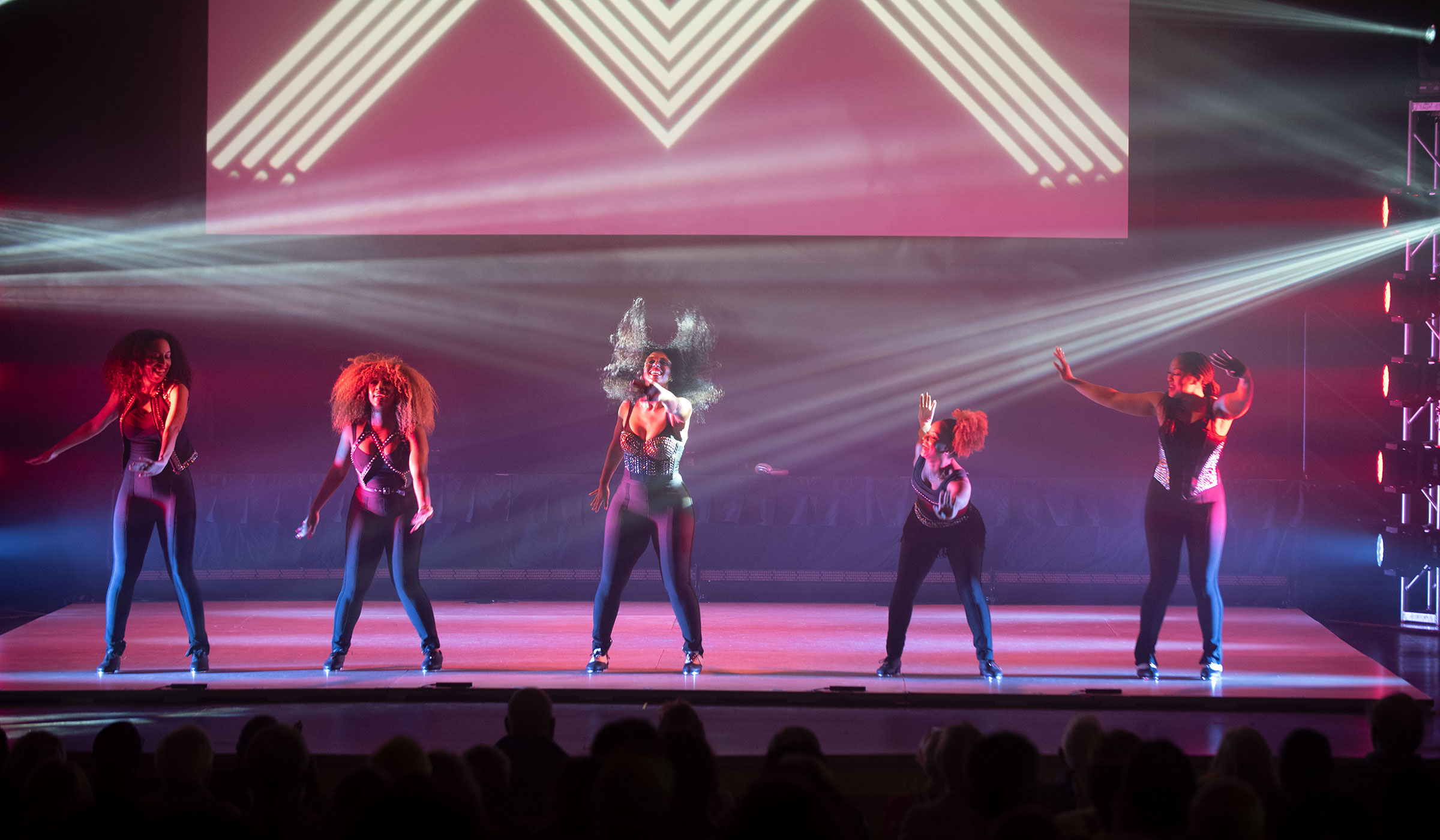 Ladies on stage with tap shoes dancing