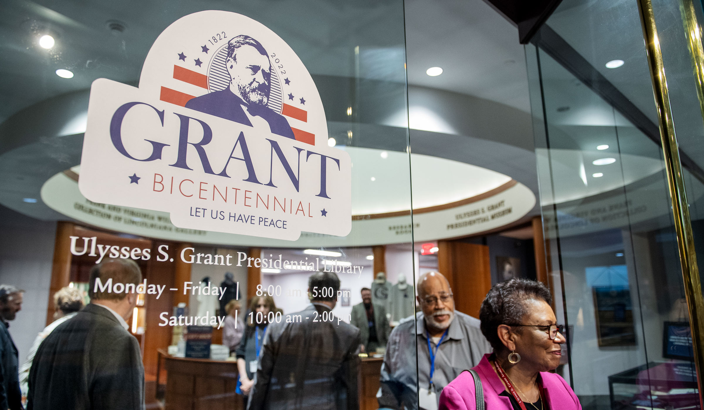 With views to the busy lobby of the Grant Presidential Library beyond, a sticker on the glass doors reads &quot;GRANT Bicentennial - Let Us Have Peace.&quot;