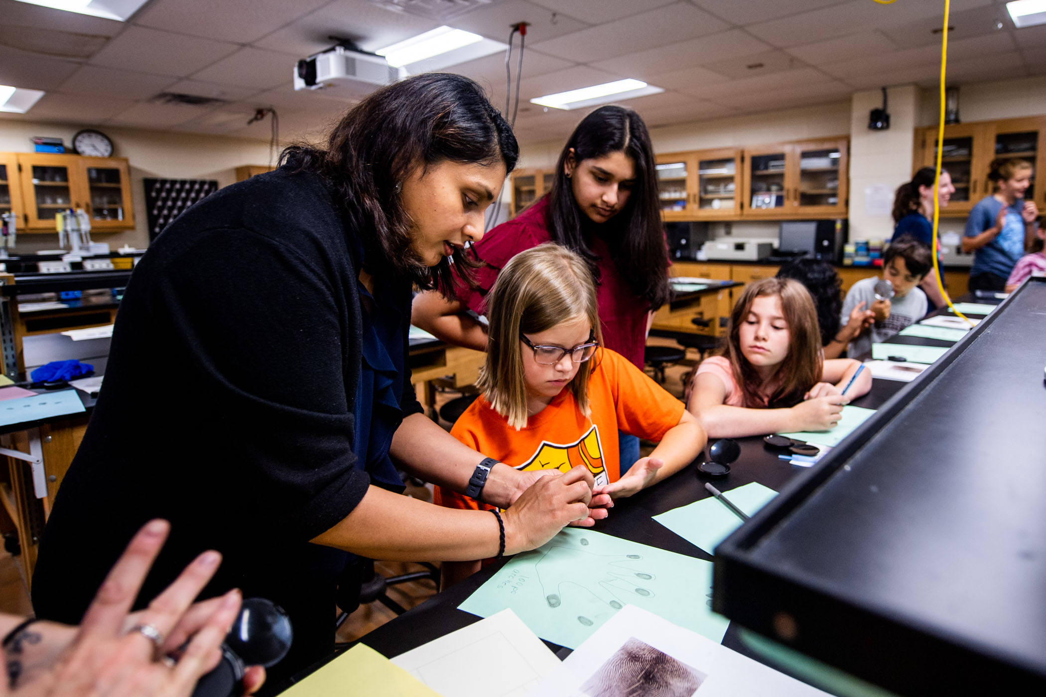 Dr. Aswathy Rai, assistant clinical professor and undergraduate coordinator in MSU&#039;s Department of Biochemistry, Molecular Biology, Entomology, and Plant Pathology, assists students participating in &quot;Thrive Thriller: Mystery Camp&quot; with performing fingerprint analysis. 