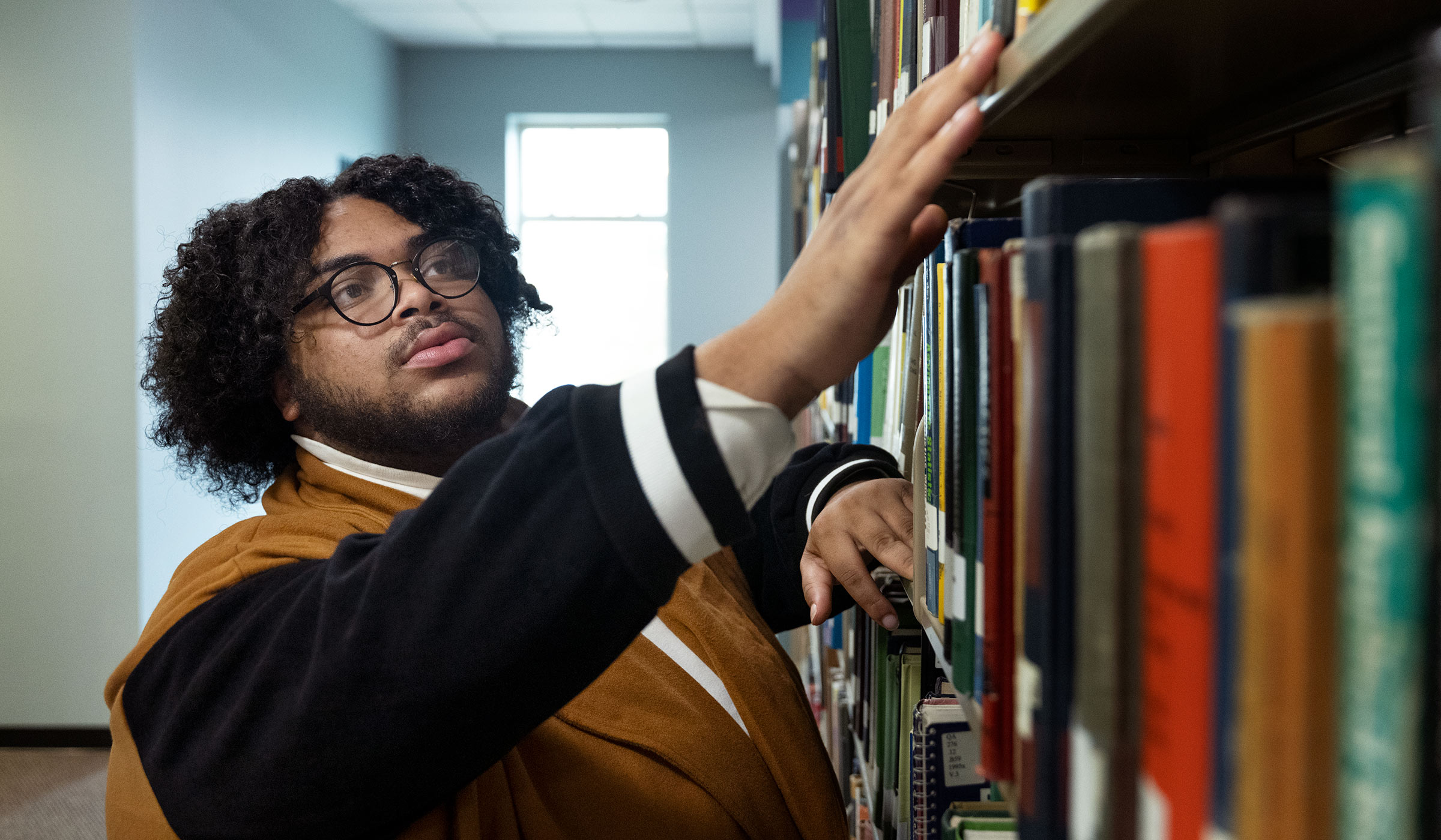 Joseph Newell, pictured among books in the MSU library