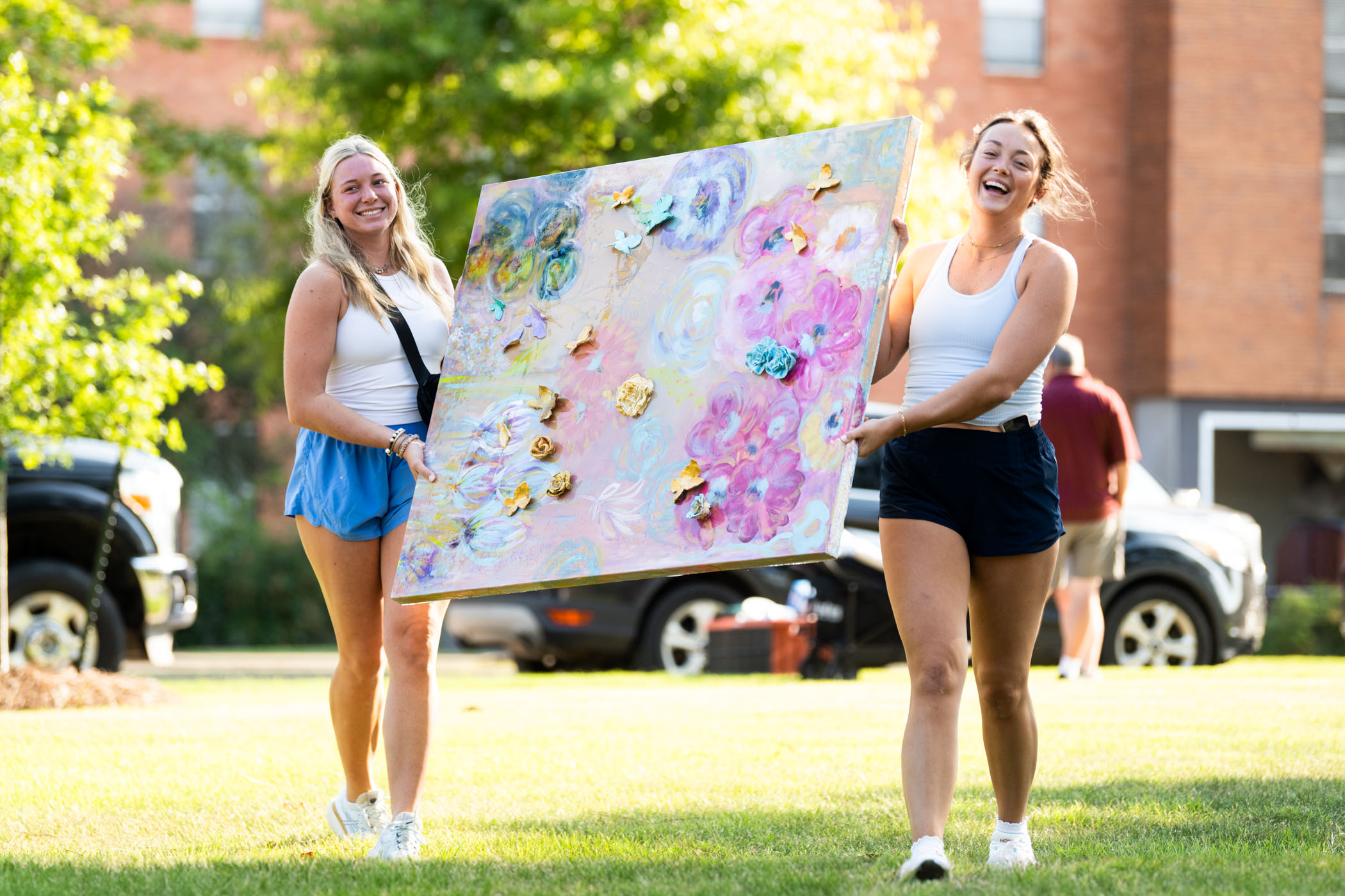 New Maroon Campers Sterling Dews (left,) and Ruth Lindsey (right,) work together to carry a pastel painting to the doors of their residence hall, preparing their dorm for the start of their Freshman year.