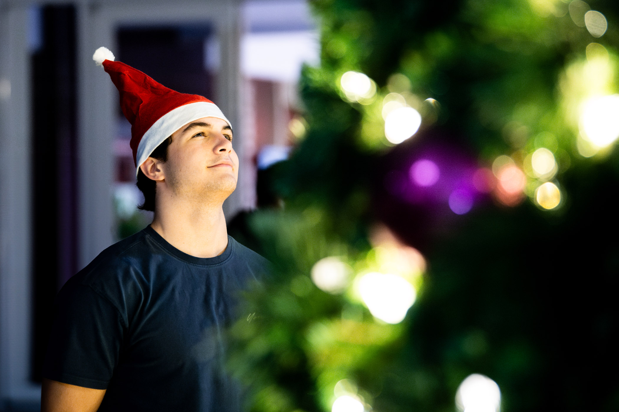 John Caleb Holbrook, a sophomore finance major from Marietta, Georgia, admires the twinkling lights of the season's beautifully lit Christmas tree outside of Colvard Student Union. The holiday season has been alive on campus, with seasonal festivities and events for students to embrace a little extra cheer before celebrations of their own.