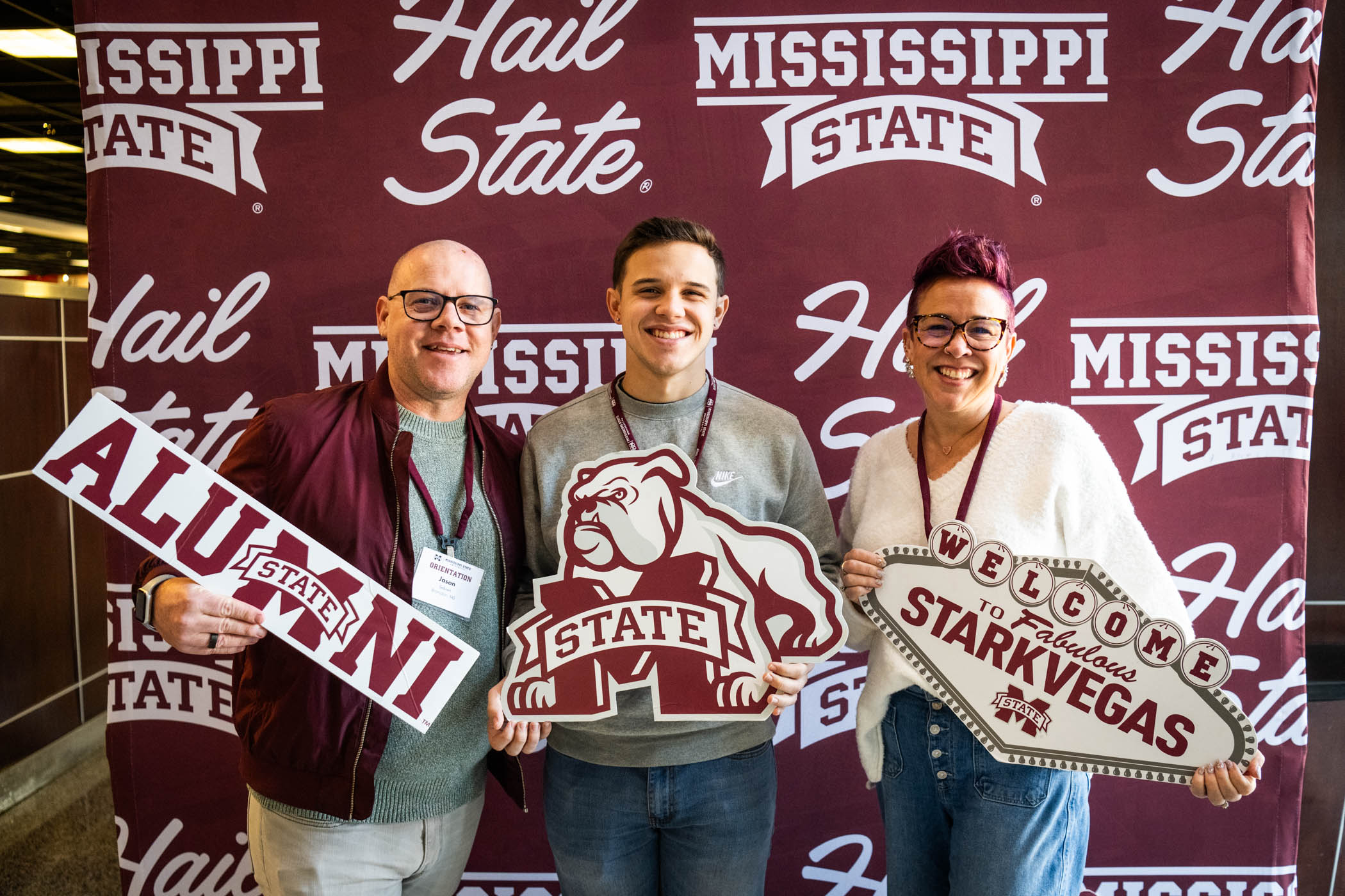 Tennyson Sebren, an incoming freshman from Brandon, MS, smiles while holding photobooth props alongside his parents at spring orientation.