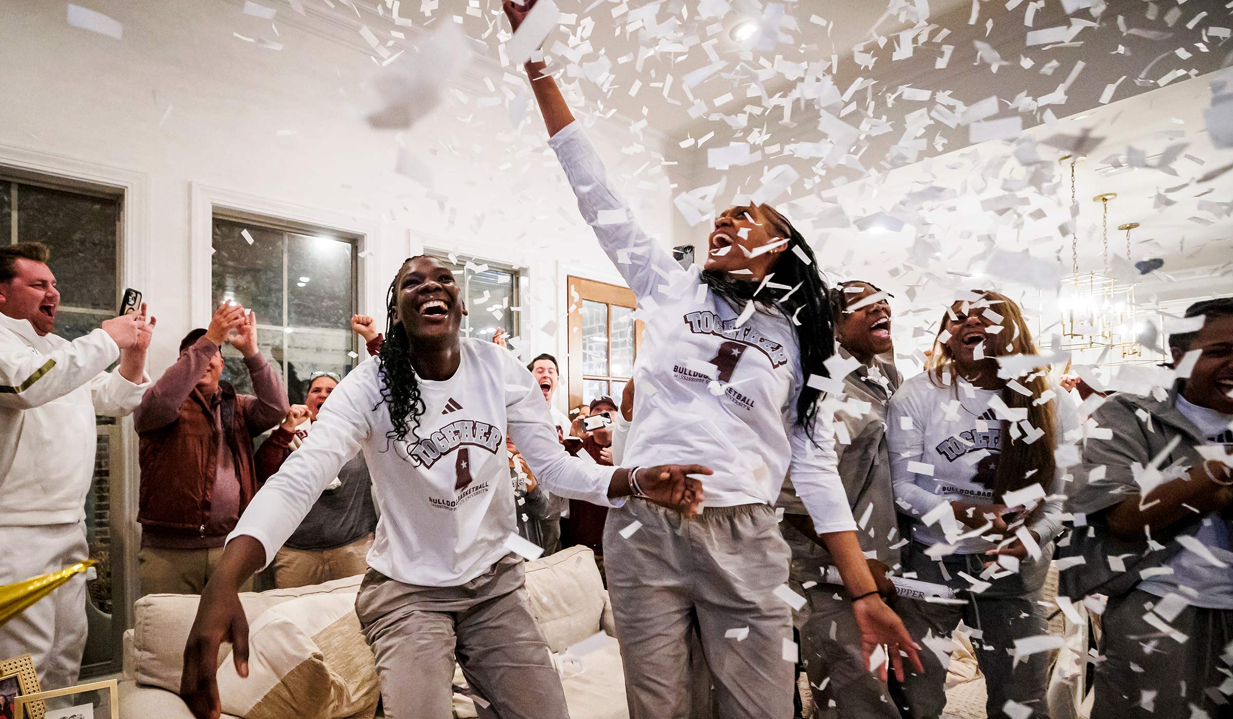 Women smiling and celebrating in white confetti
