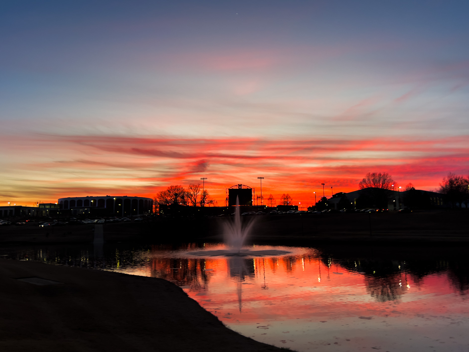 A vibrant evening sunset paints the skies over MSU's Chadwick Lake walking trail and the athletic district, a perfect preview of longer days and warmer opportunities to exercise for outdoor recreationalists on campus.