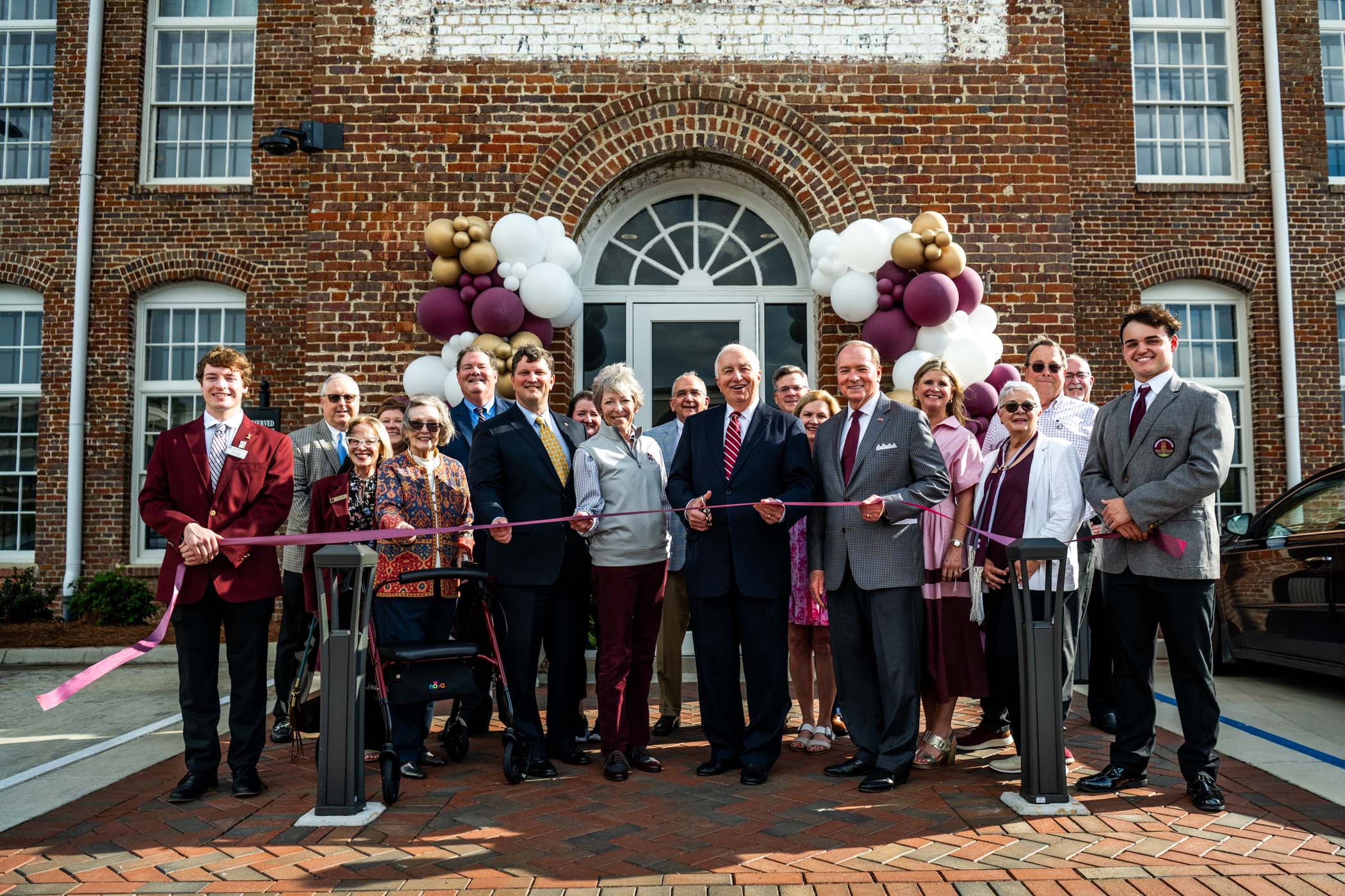 University leaders and supporter celebrate a ribbon-cutting at The Mill