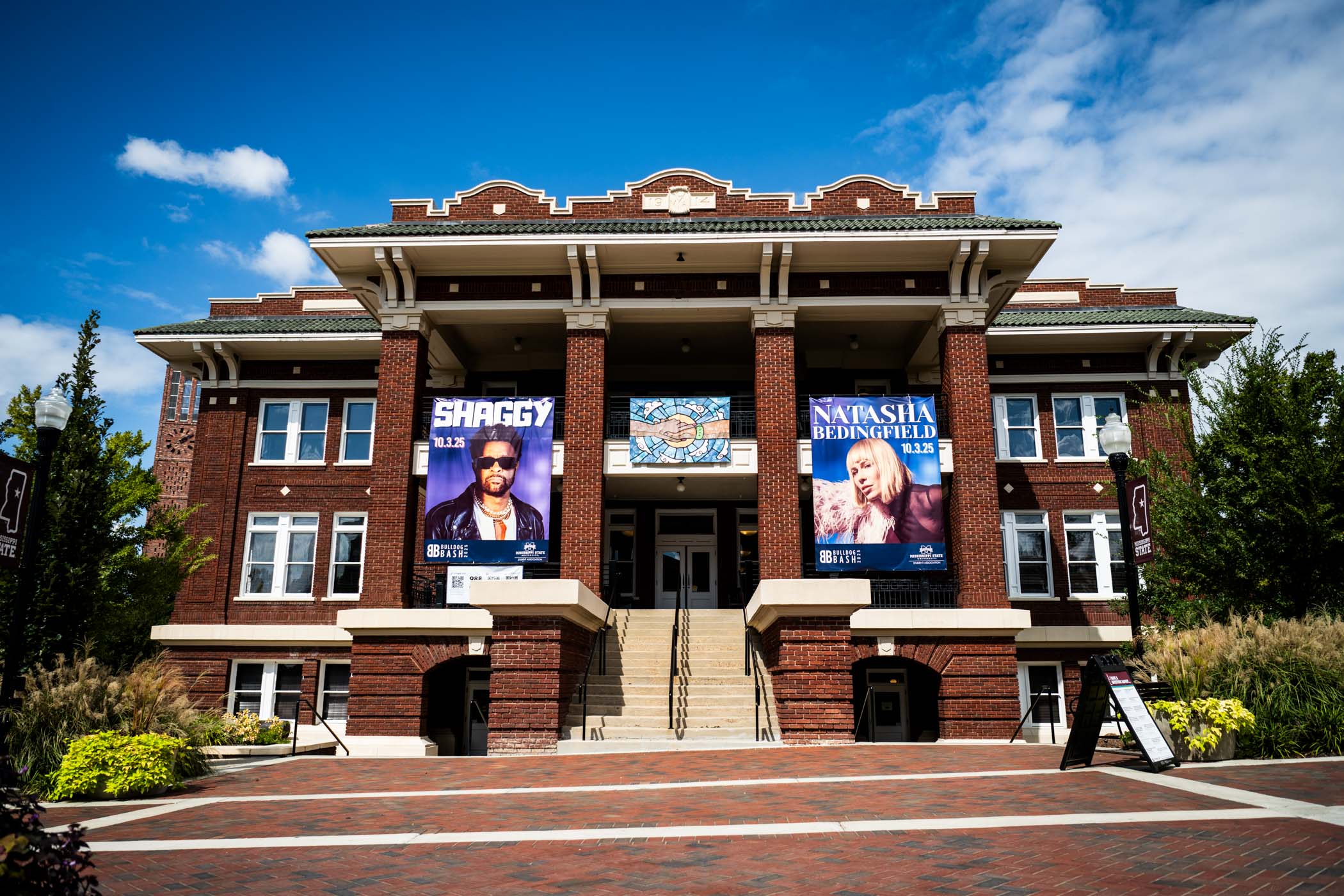 Banners hang from the YMCA Building balcony to promote Bulldog Bash, Mississippi’s largest free outdoor concert [Sep. 26.] Set for Friday, Oct. 3, this year’s event will feature Shaggy and Natasha Bedingfield and, in a historic first, transition indoors to Humphrey Coliseum to elevate the concert experience while avoiding construction downtown. 