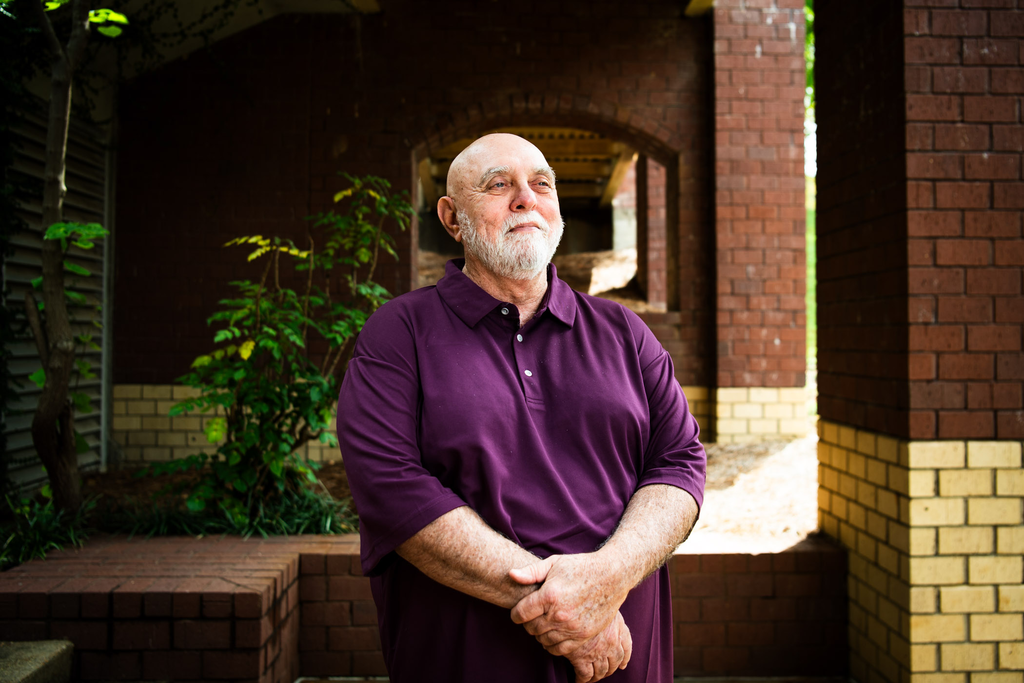 man standing in maroon shirt
