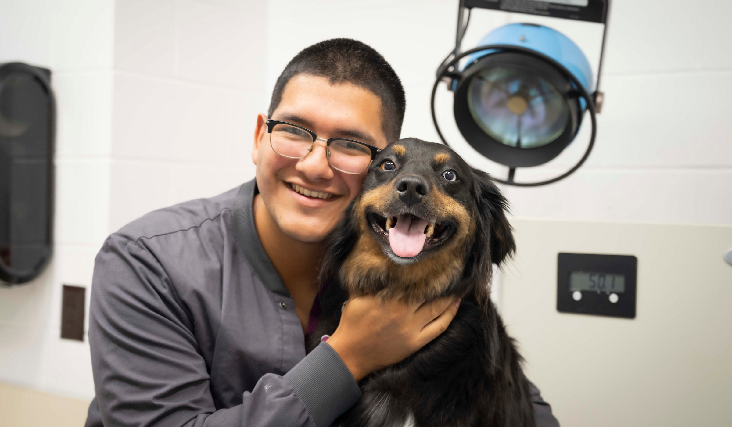 Eliu Puerto poses with a dog in an environmental portrait