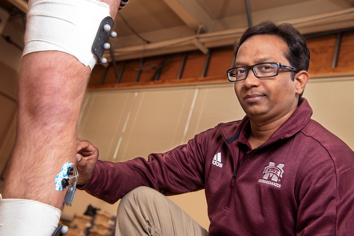 Harish Chander demonstrates equipment in the neuromechanics lab.