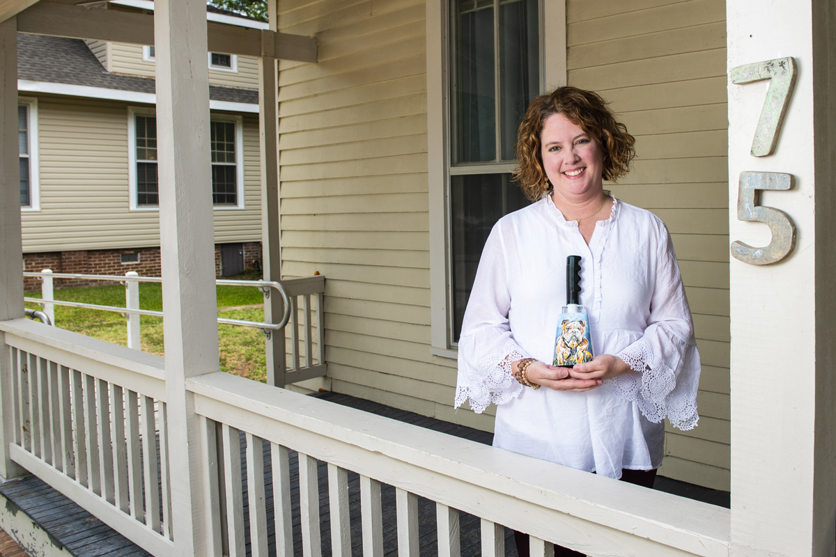 Christa King, pictured holding a Bulldog cowbell.