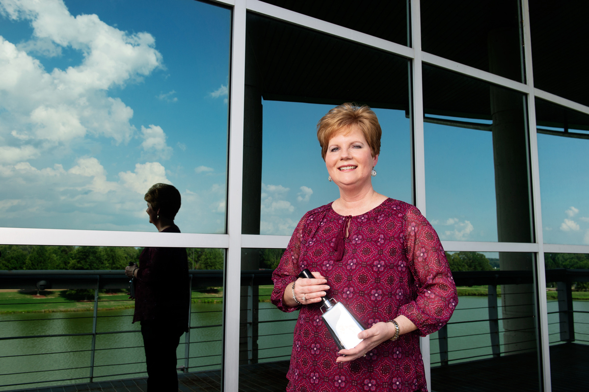 Jana Flint, pictured holding a cowbell outside of the Bryan Building.