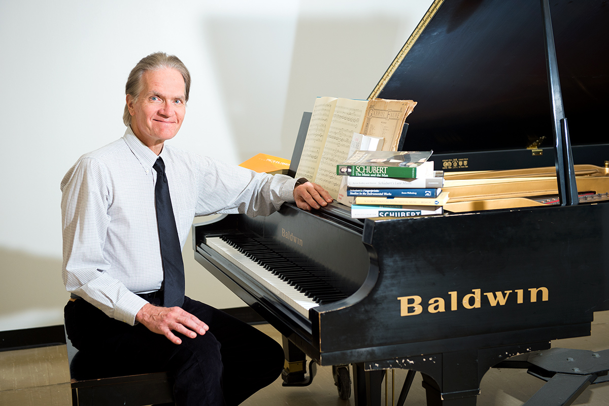 James Sobaskie, pictured at a piano with books on classical composers.