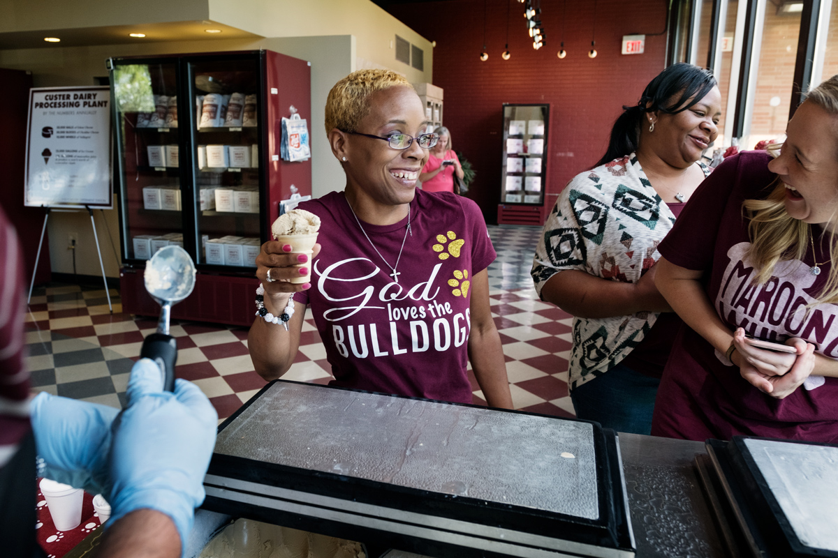 Three MSU Admissions staff share a laugh while receiving their free cones of MSU Ice Cream at the MAFES Store.