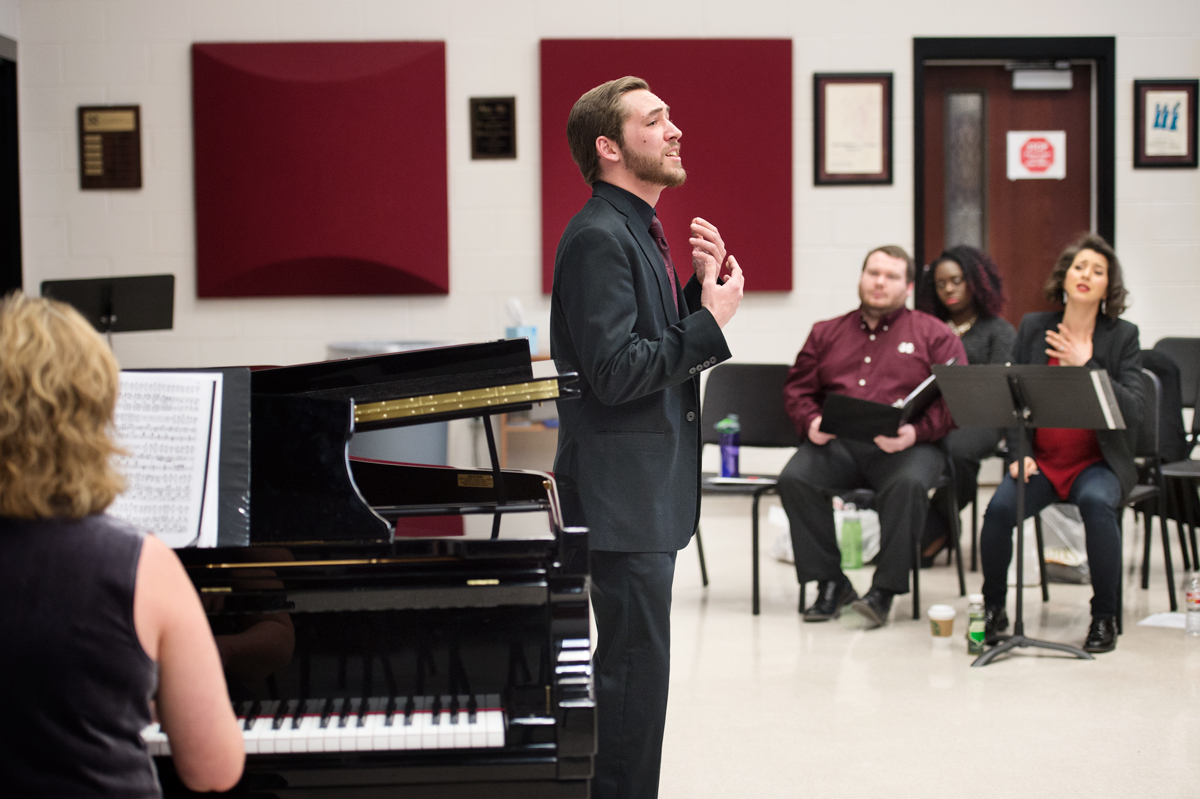 Student John Williams sings opera in the Choral Rehearsal Hall, with piano accompaniest in foreground.