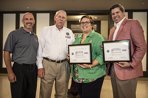 Jimmy Vaughan, a volunteer with the U.S. Department of Defense’s Employer Support of the Guard and Reserve program, presents Patriotic Employer awards to MSU Vice President for Student Affairs Regina Hyatt and Assistant Vice President for Student Affairs Jeremy Baham on Thursday [July 12]. Brian Locke, far left, is the director of MSU’s G.V. “Sonny” Montgomery Center for America’s Veterans. (Photo by Logan Kirkland)