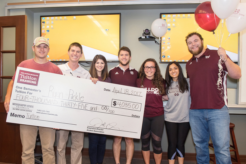 Monroe Countian Ryan Pickle (left) accepts the MSU Alumni Association’s Tuition Drawing award from Will Basden, MSU Alumni Delegates president, and other delegates (third from left to right) Ashley Vargason, Chris Morgan, Abby Sparks, Dipa Patel and Jake Thomas. (Photo by Beth Wynn)