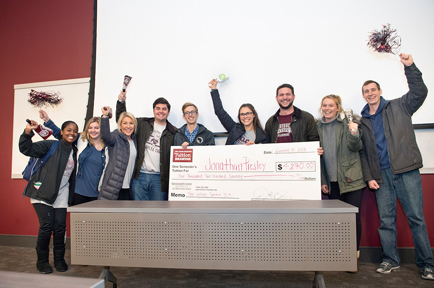 Jonathan P. Presley of Olive Branch (fifth from left) receives "free" tuition from members of the MSU Alumni Delegates on Wednesday, Nov. 14. (Photo by Megan Bean) 