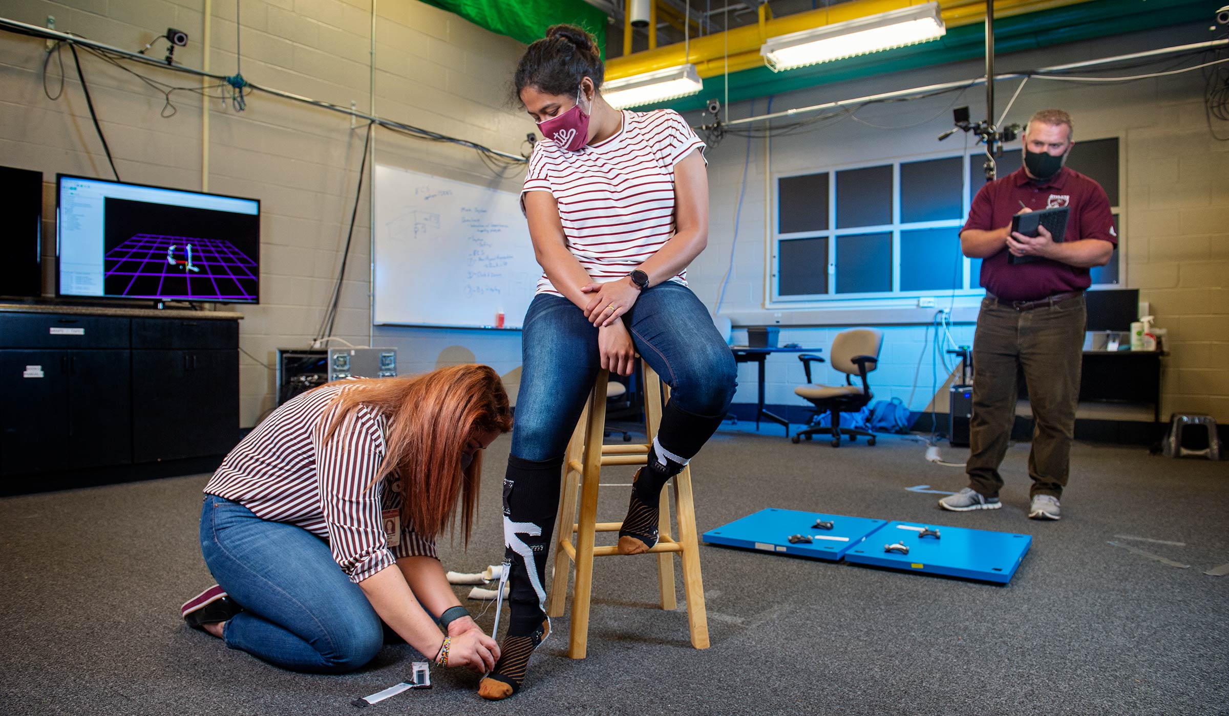 Graduate students adjust sensors in Reuben Burch's research lab at CAVS.