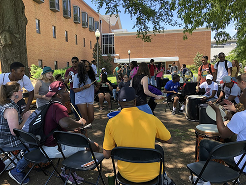 Students participate in a community drum circle near Colvard Student Union