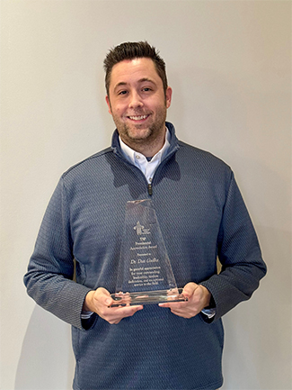 Professor Dan Gadke holding the national Presidential Appreciation Award from the Trainers of School Psychologists