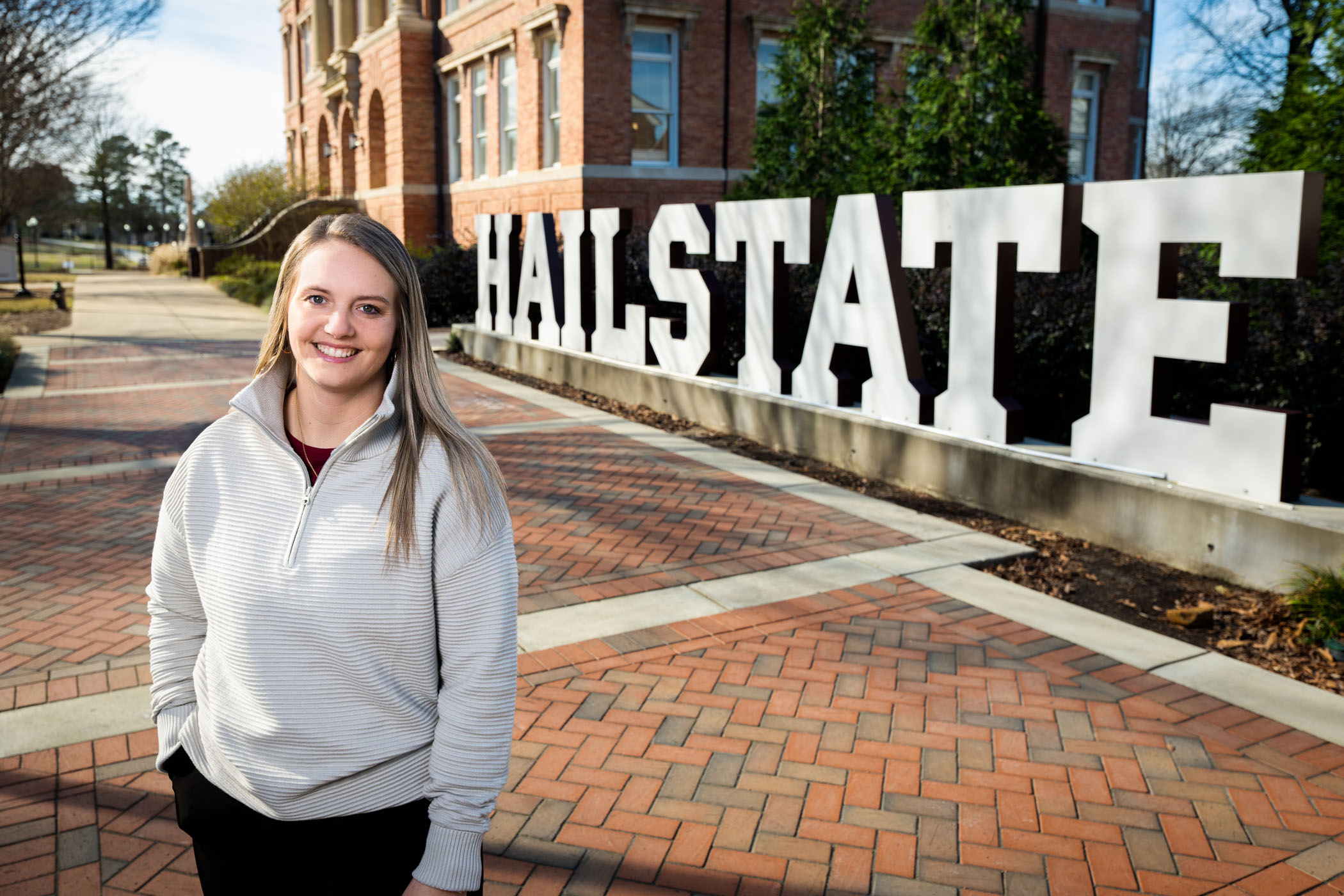 Mikela Barlow at the Hail State sign