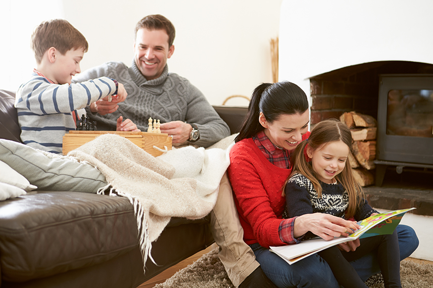 A family reads a book and plays games together.