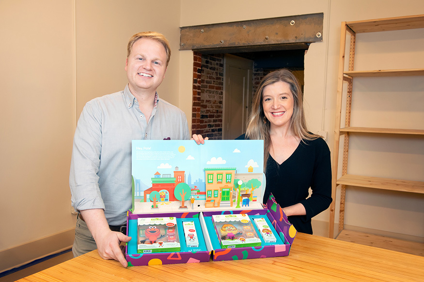 Anna Barker and Hagan Walker hold packages of Glo Pal characters.