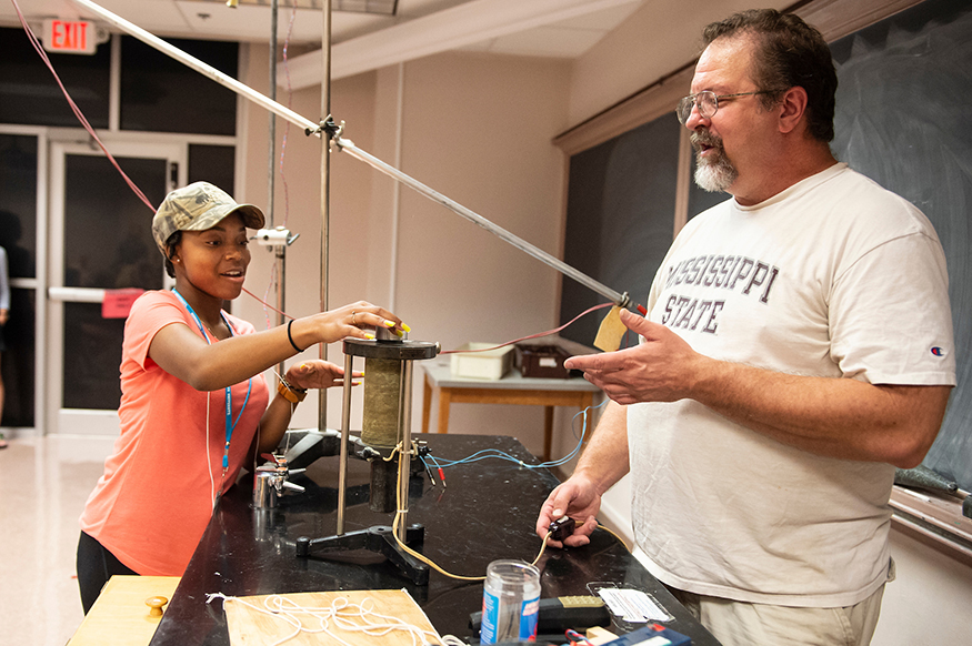 Kristen Ellis, a senior at Holmes County Central High School, assists with a demonstration from Jeff Allen Winger, a Mississippi State University professor of nuclear physics. Winger’s demonstrations were part of the AP physics preparatory academy held at Mississippi State University this summer. (Photo by Logan Kirkland)