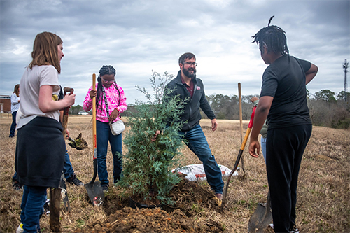 Josh Granger with students planting a cedar tree for MSU’s Arbor Day celebration. 
