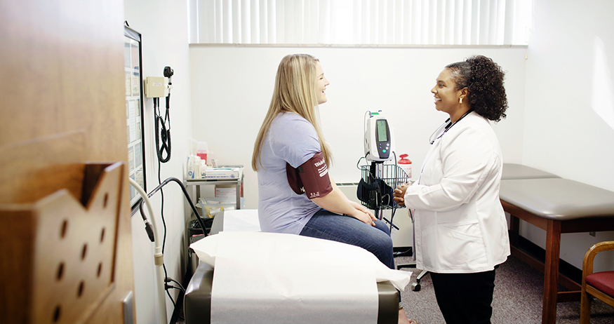 Dr. Katrina Poe visits with a patient at the Longest Student Health Center. 