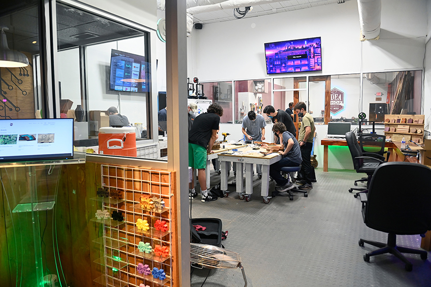 Participants gather around a table during a guitar building workshop at the MSU Idea Shop.