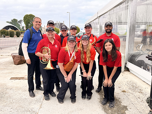 Pictured are Mississippi State Associate Director of Bands Craig Aarhus, left, and nine current and former members of the Famous Maroon Band who participated in the D-Day 80th Anniversary Collegiate Mass Band.