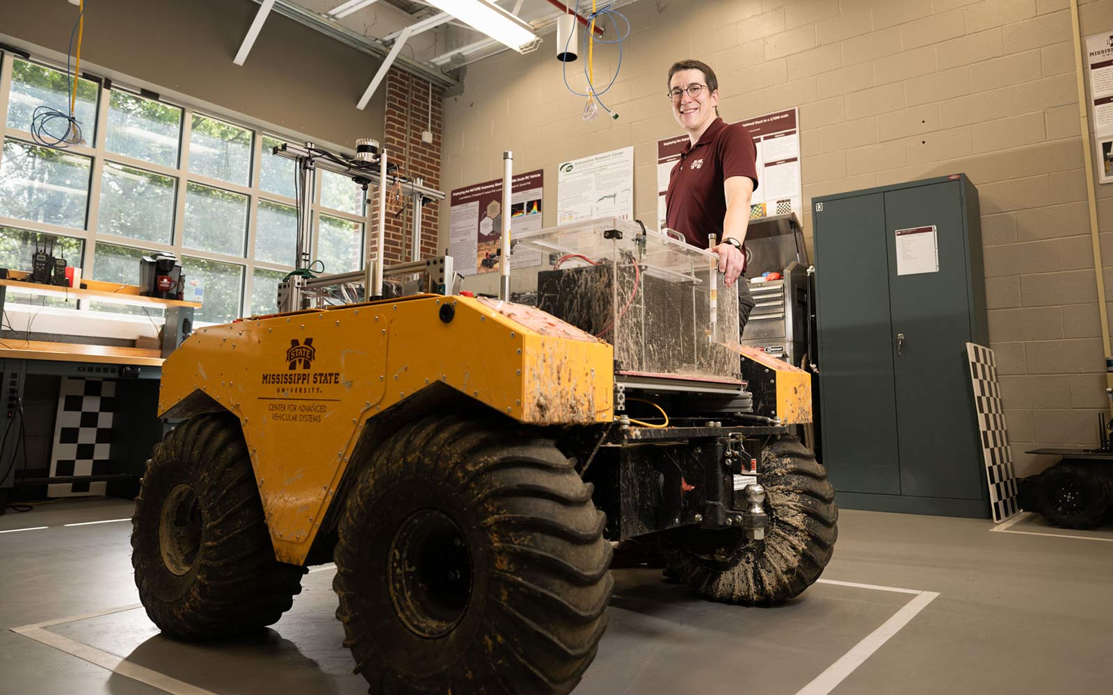 Marc Moore stands next to an autonomous robot he built