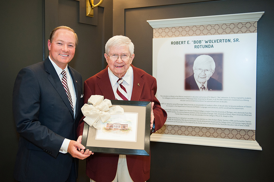 Mark Keenum presents a painting of Old Main to Robert Wolverton