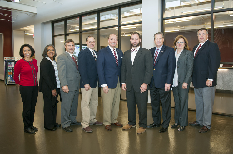 University and USPS officials pose following a ribbon cutting for the newly renovated Roberts Building at MSU. Pictured, from left to right, are: Post Office Retail Manager Lupe Licudine, Retail Specialist Monica Tucker, North Central Post Office Operations Manager Jeff Harrell, MSU Postmaster Ken Oglesbee, MSU President Mark E. Keenum, MSU Director of Parking, Transit and Sustainability Jeremiah Dumas, Executive Director of Campus Services George Davis, Vice President for Campus Services Amy Tuck and Assistant Director of Parking and Transit Services Ronnie White. (Photo by Russ Houston)