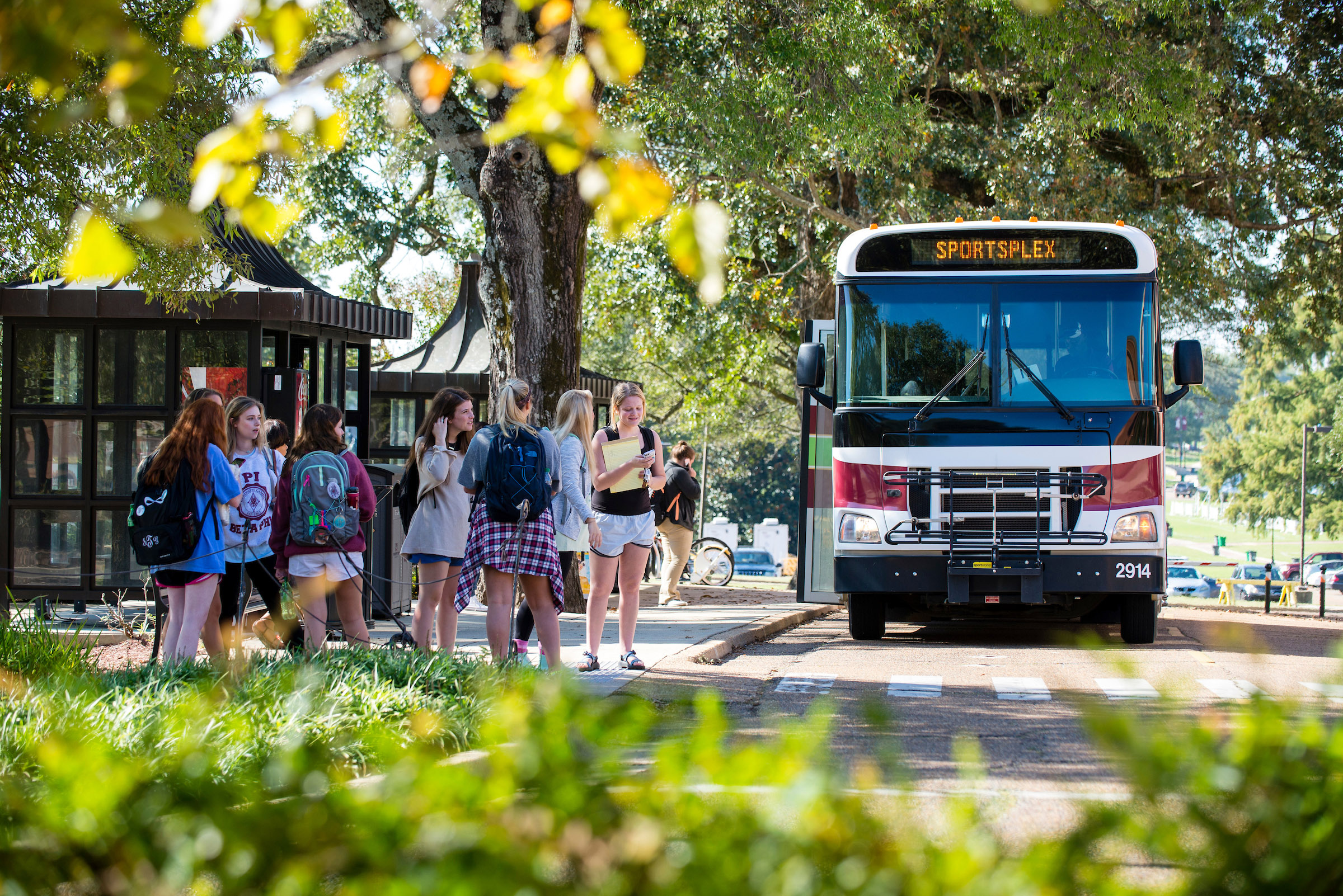 Mississippi State students wait to get on a bus at the Montgomery Hall bus stop, part of the Starkville-MSU Area Rapid Transit system. More students and community members than ever before are using the SMART bus system, while the university is currently adding more than 1,000 parking spaces to meet growing parking demand. (Photo by Marco Lopez)