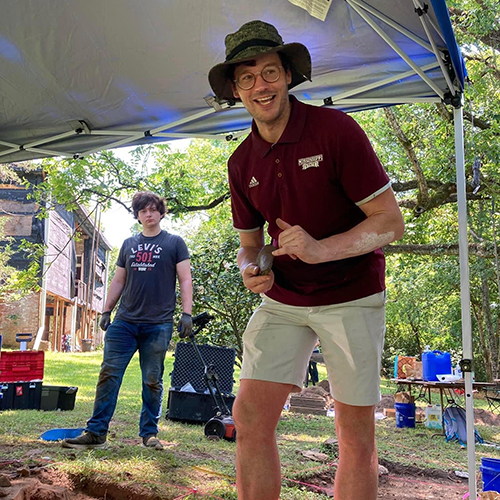 Shawn Lambert poses for a picture while digging at an archaeological site