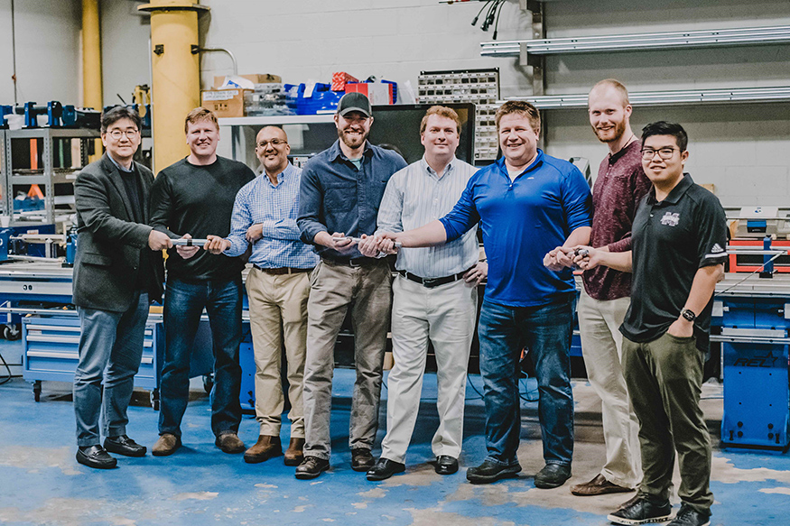 MSU and REL personnel pose with their serpentine bar technology. 