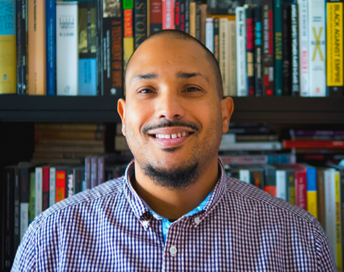 Ted Thornhill is pictured smiling in front of a bookshelf.