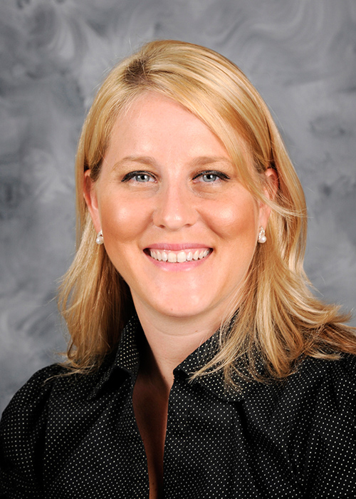 Close up studio portrait of Dr. Cathleen Mochal-King in front of a gray background