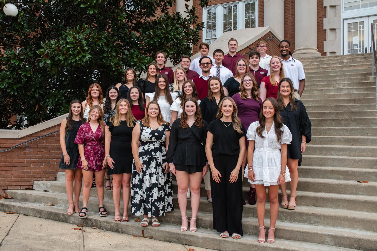 Members of the 2024 cohort of Mississippi State’s Mississippi Excellence in Teaching Program pose on the steps of a campus building.