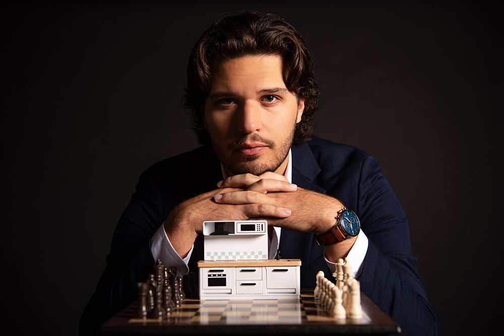 Russell Pair, a Mississippi State senior majoring in secondary education, is pictured with a chess set and a small, toy kitchen set.