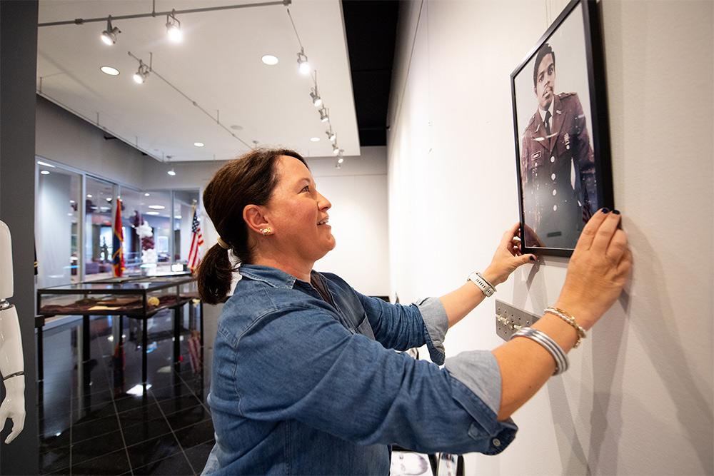 University Archivist Jessica Perkins-Smith adjusts a framed picture of Col. Robert L. Barnes Jr., one of Mississippi State’s earliest Black graduates and ROTC members, featured in the current art exhibit “Student Salutes: A Visual Tribute to MSU Veterans” in the Colvard Student Union Art Gallery. Barnes was awarded an MSU Doctor of Public Service Degree in 2022.
