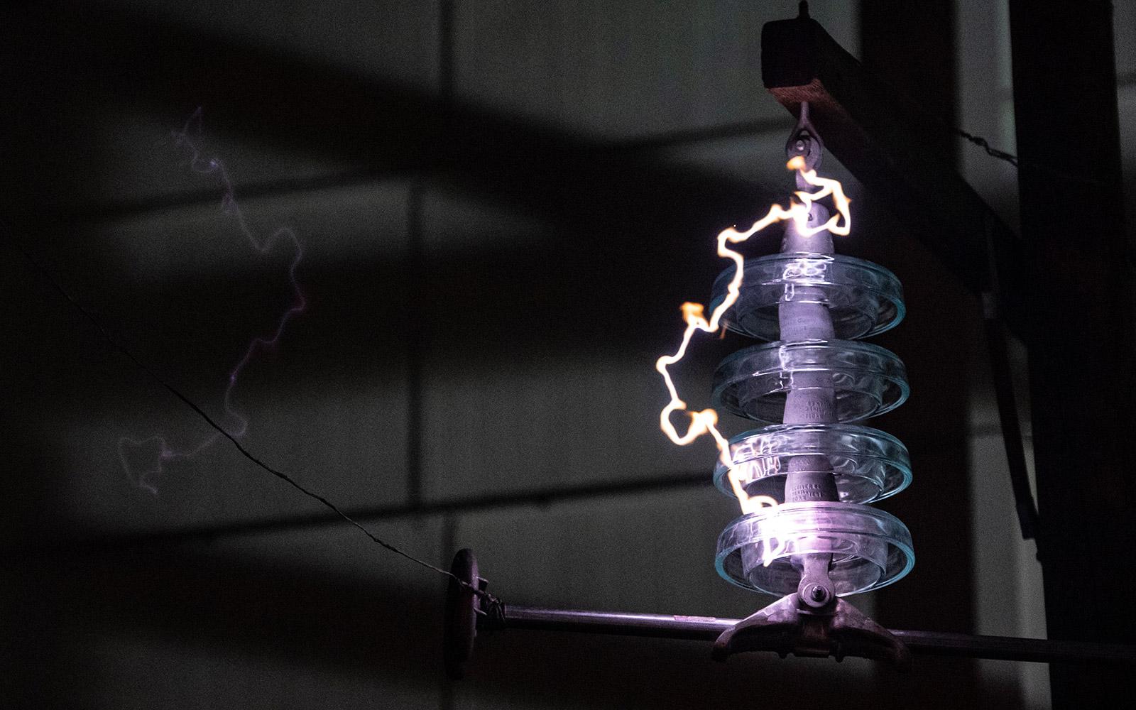 A bolt of electricity makes its way through equipment in MSU&#039;s Paul B. Jacobs High Voltage Laboratory. As the largest lab of its kind among North American universities, it serves as a university research center for high voltage engineering. To help electrical companies during disasters, MSU recreates a variety of real-world scenarios inside the lab—falling trees, thunderstorms, solar radiation, high salt concentrations and more. (OPA photo)