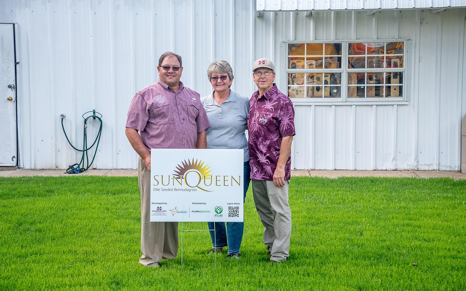 Jim Mitchell, Melodee Fraser and Wayne Philley on the Sun Queen lawn planted outside of Advantage Doors in West Point. (Photo by Dominique Belcher)