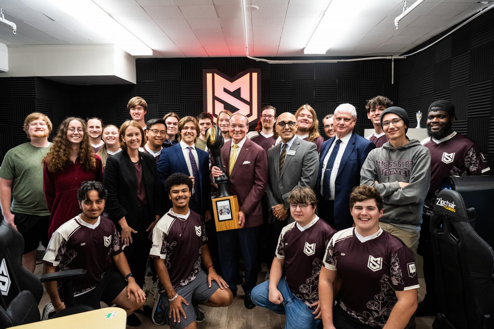 MSU President Mark E. Keenum, center, holds the university’s 2024 Esports Egg Bowl trophy—celebrating MSU Esports new, upgraded facility in Butler Hall with student Esports team members. (Photo by Grace Cockrell)