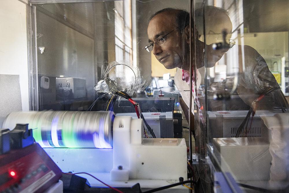 Mississippi State chemical engineering professor Santanu Kundu observes an electrospinning device in Swalm Chemical Engineering Building.