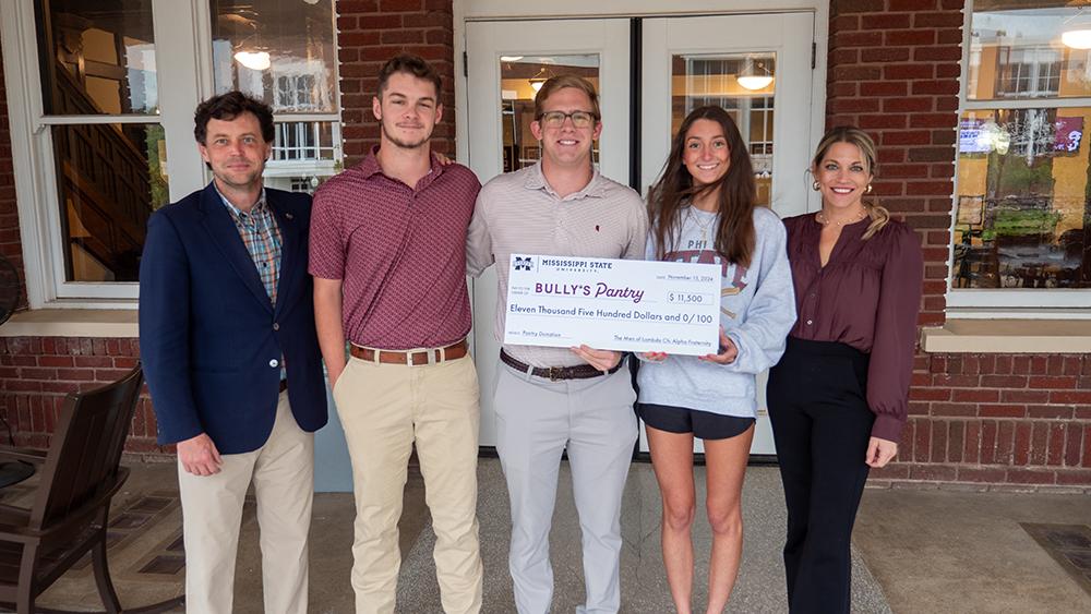 Mississippi State Lambda Chi Alpha fraternity and university representatives pose with an $11,500 check donated to Bully&#039;s Pantry.