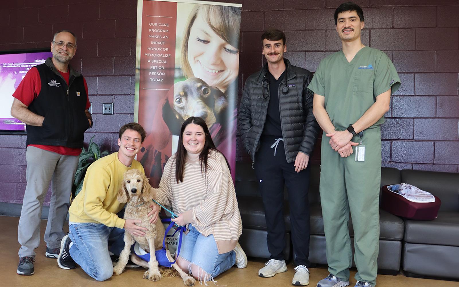 The Mississippi State Animal Health Center reunites Maple with her owners. From left, MSU Service Chief of Small Animal Surgery Dr. Michael Jaffe, Dylan McCay, Maple, Emily Roberts, third year Doctor of Veterinary Medicine Will Greer and surgical resident Dr. Alex Chu. (Photo by Amelia Anderson)